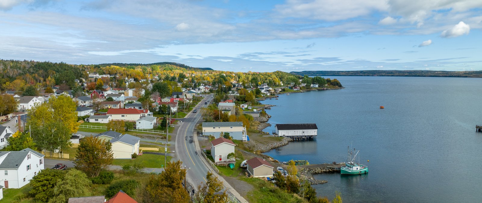 Lewisporte main street along Notre Dame Bay in fall — the whole town at a glance, fishing boat at the wharf